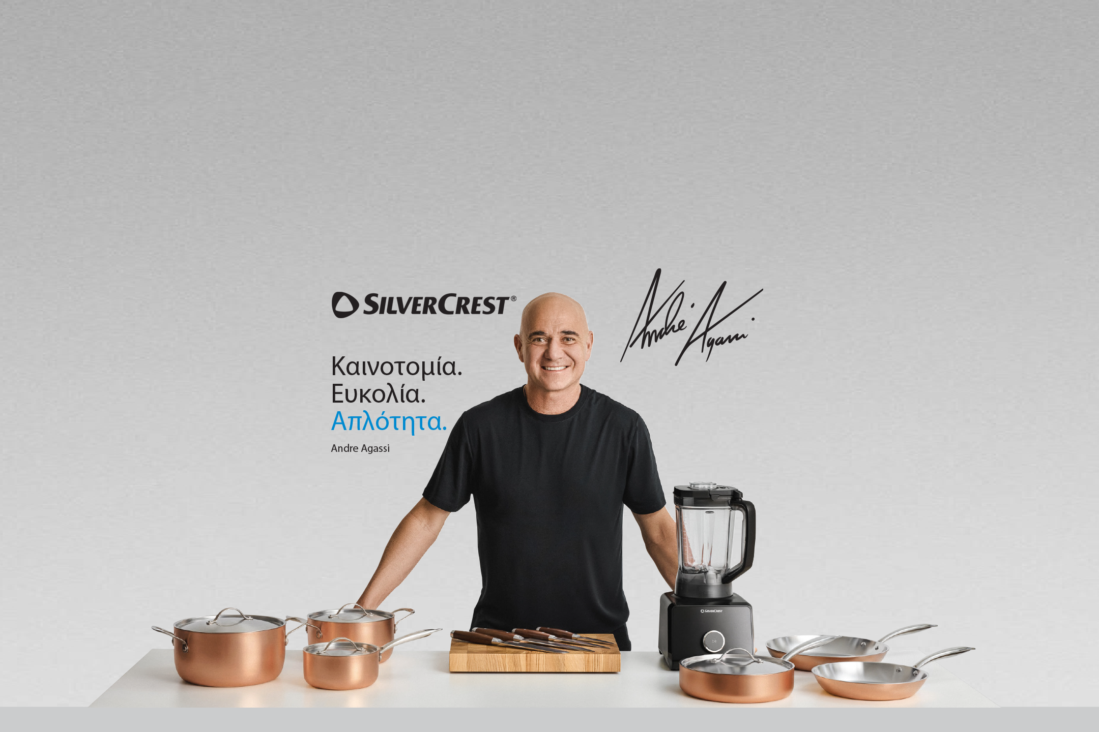 Διαφημιστικό banner της Silvercrest με τον Andre Agassi, το σλόγκαν 'Καινοτομία. Ευκολία. Απλότητα.' και μια σειρά από χάλκινα σκεύη μαγειρικής και ένα μπλέντερ.