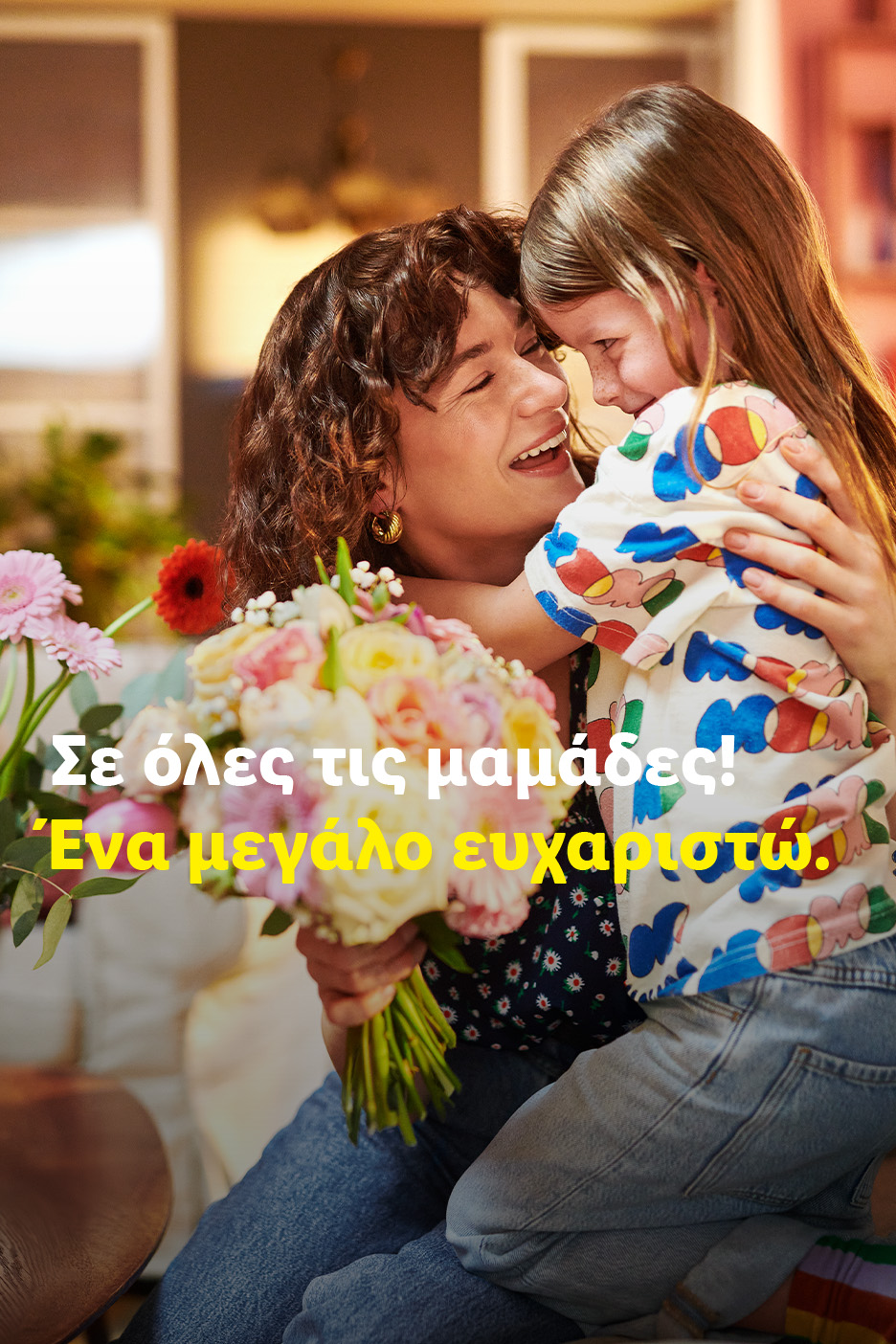 Μητέρα και παιδί αγκαλιάζονται, κρατώντας ένα μπουκέτο λουλούδια. Κείμενο: Σε όλες τις μαμάδες! Ένα μεγάλο ευχαριστώ.