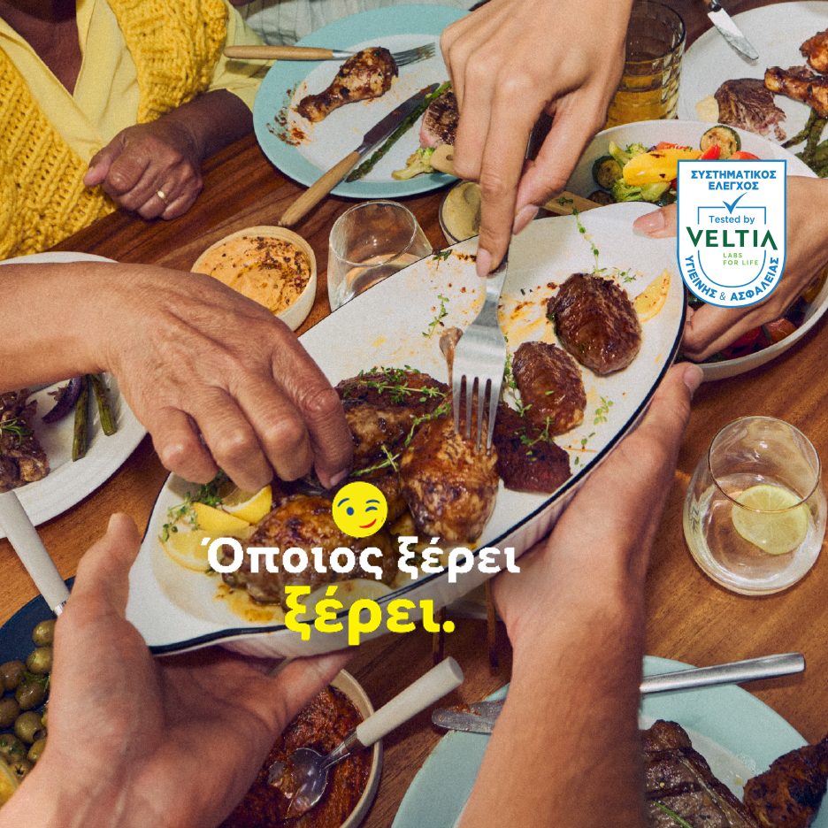 Άνθρωποι μοιράζονται ένα γεύμα με διάφορα πιάτα, όπως κρέας και λαχανικά, σε ένα ξύλινο τραπέζι.