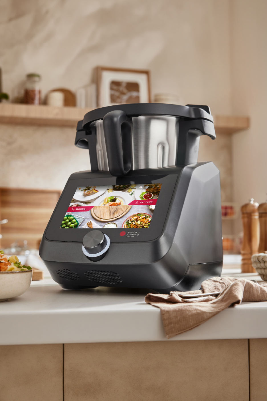 Μια έξυπνη συσκευή κουζίνας με μεγάλη οθόνη που εμφανίζει συνταγές, σε πάγκο κουζίνας.