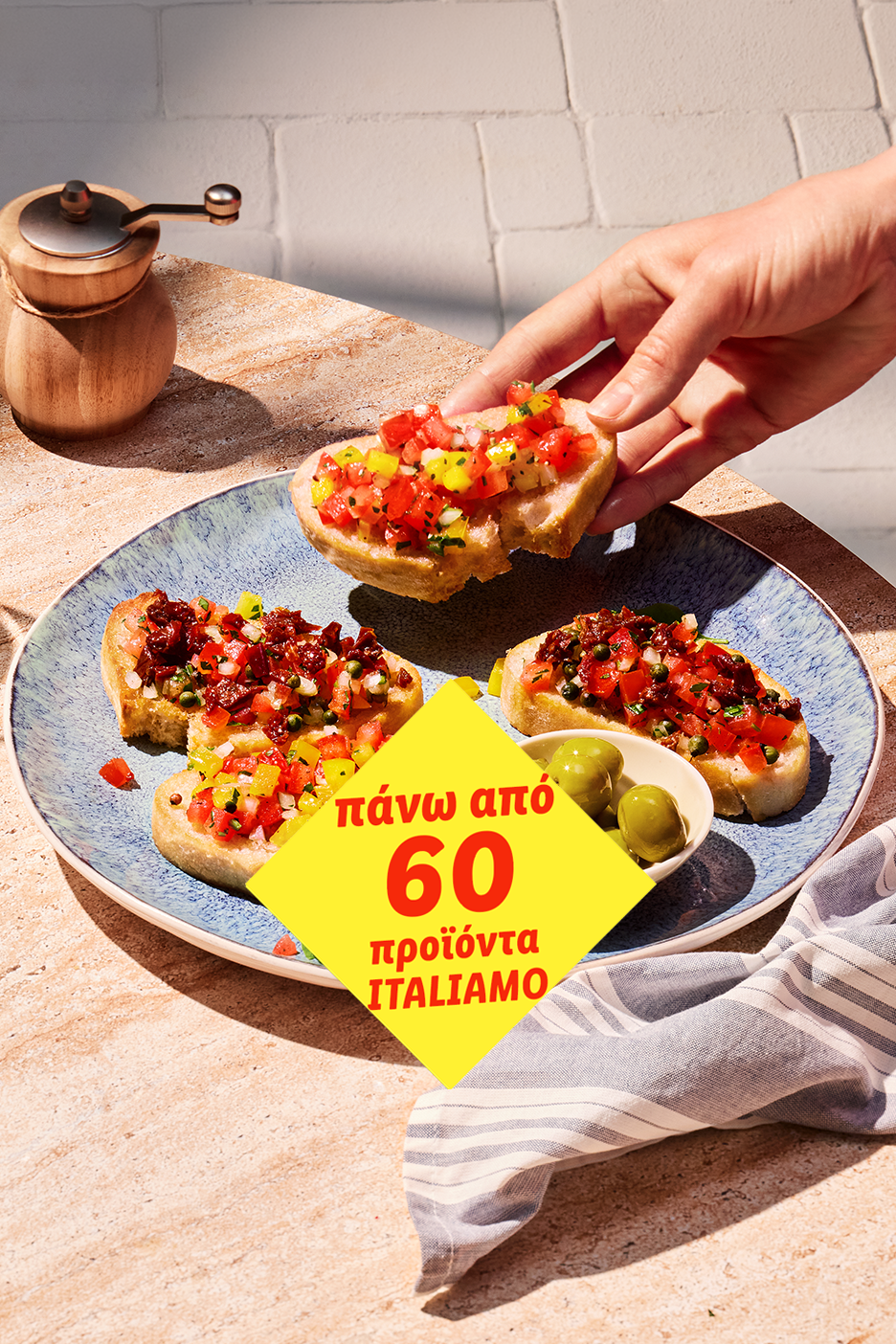 Μπρουσκέτες με ντομάτα και πιπεριά, ελιές και μύλο πιπεριού σε τραπέζι.