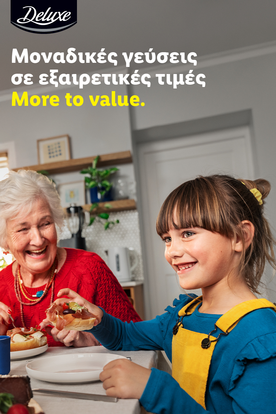 Γιαγιά και παιδί απολαμβάνουν ανοιχτά σάντουιτς. Κείμενο: «Μοναδικές γεύσεις σε εξαιρετικές τιμές. More to value.»