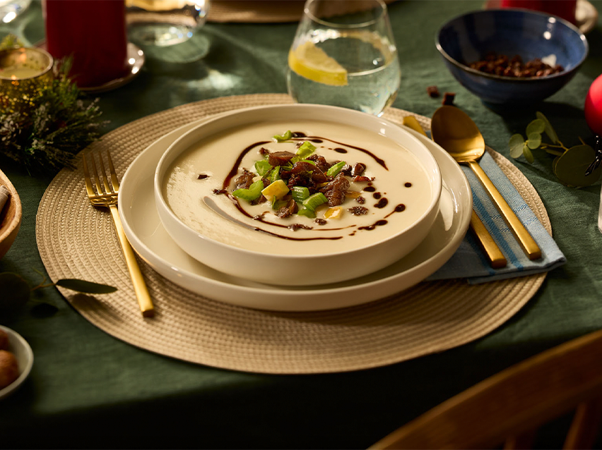 Κρεμώδης σούπα με κρέας και λαχανικά, σερβιρισμένη σε γιορτινό τραπέζι.